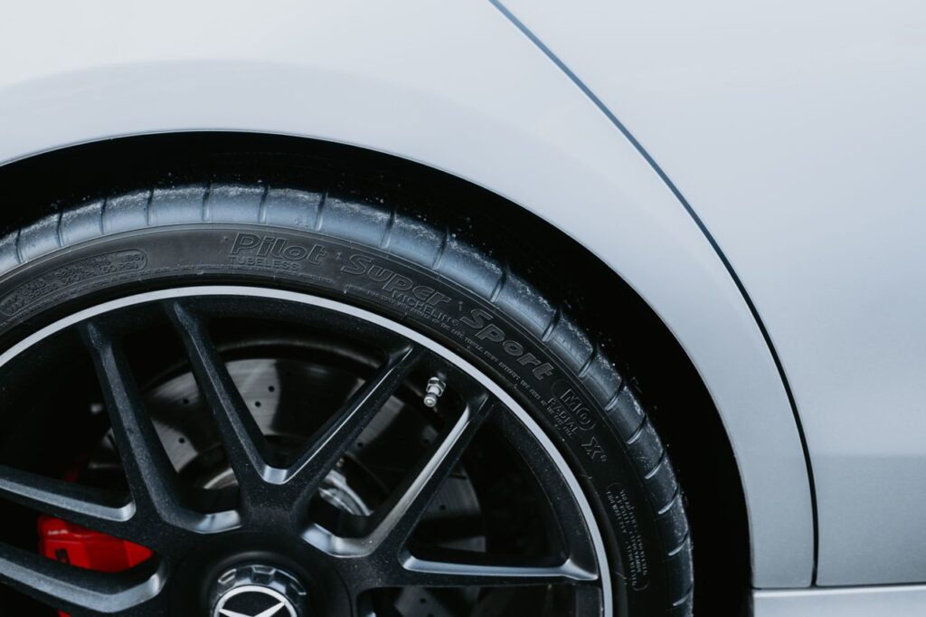 Detailed view of an alloy wheel with a high-performance tire on a sleek vehicle.
